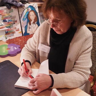Karin Büchel signiert ein Buch