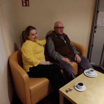 Zwei Personen sitzen an einem Tisch bei einem Kaffee